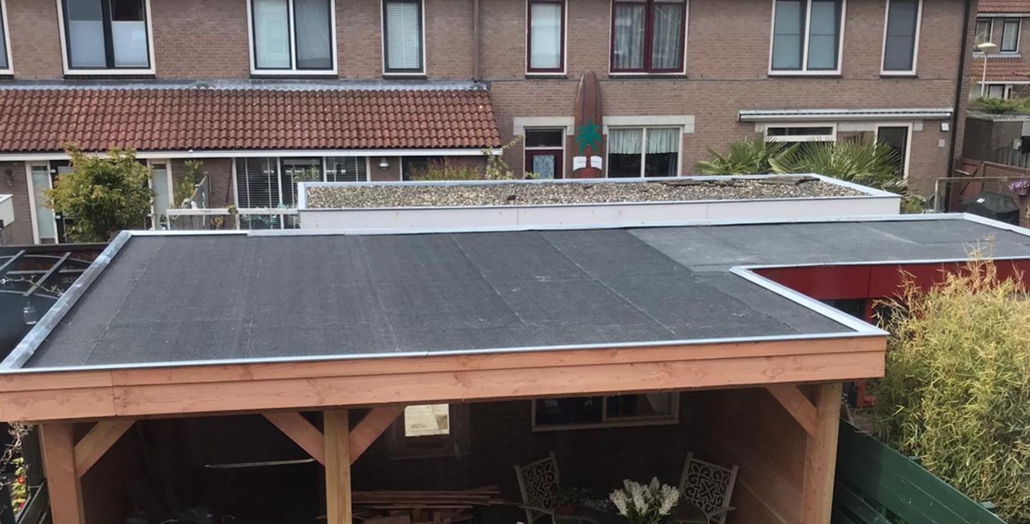Na: de overkapping met een afgewerkt zwart bitumen dak